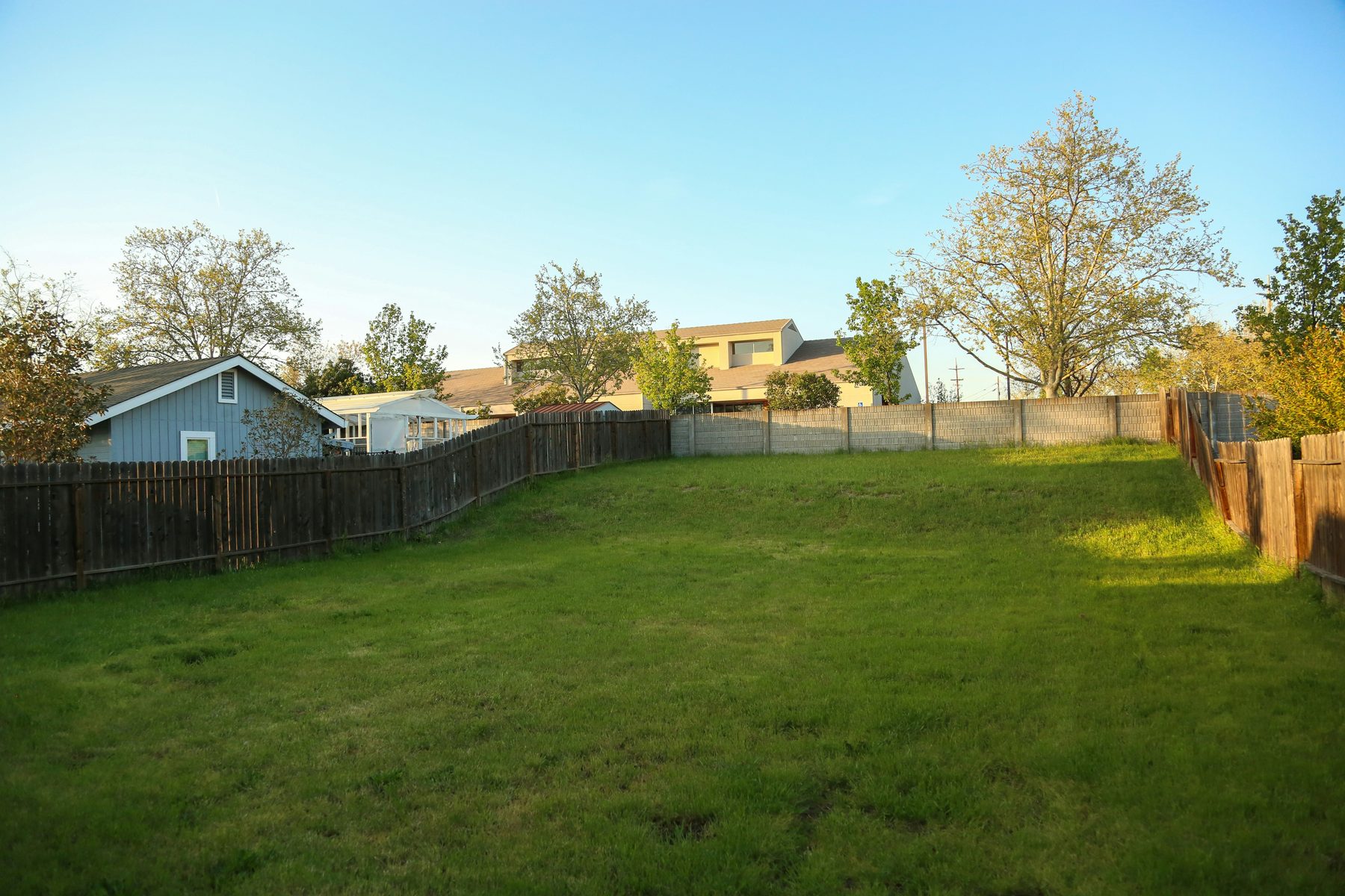 Wood privacy fence around a suburban back lawn